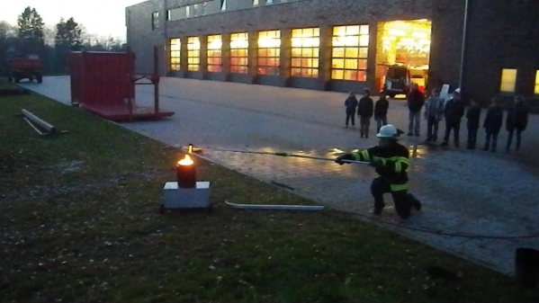 Der Feuerwehrmann nähert sich vorsichtig der brennenden Pfanne