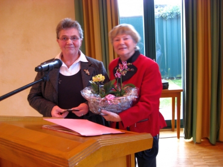 Linda Kramer (li.) Vorstandsmitglied überreicht Friedegund Reiners, 1.Vorsitzende zum Dank einen Blumenstrauß