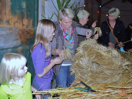 Kinder binden unter Anleitung ihre kleine Erntekrone