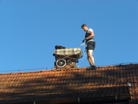 Mann mit Kinderwagen auf dem Dach.