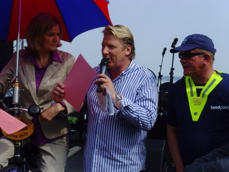 Heike Goetz auf dem Hochrad, gestützt von Ludger Abeln, rechts der Organisator der Radtour, Rainer Cordes