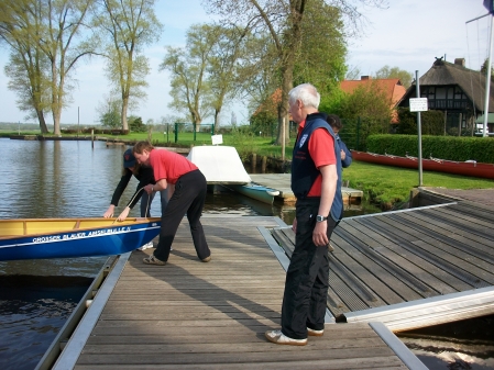 Ruderboot wird ins Wasser geschoben